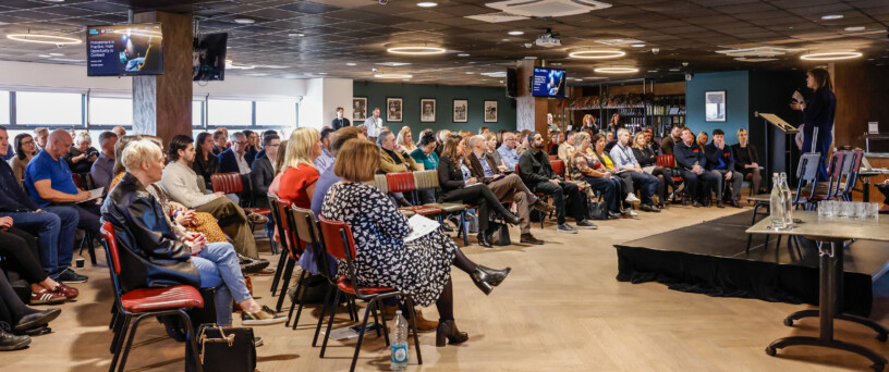 Audience listening to speaker at a procurement event Mobile